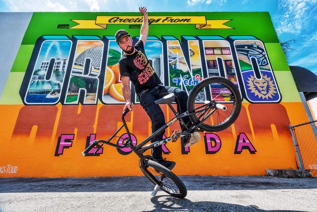Scott Weaver, BMX Flatland Freestyler, doing a trick in front of an Orlando mural.